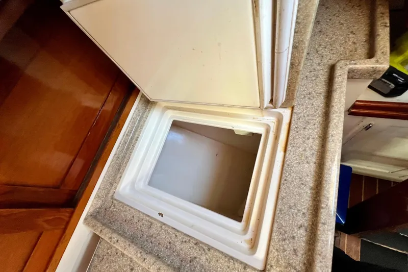 Slide: The Image of Open storage compartment on a 1975 Cape George 36 boat with granite countertop. - 71