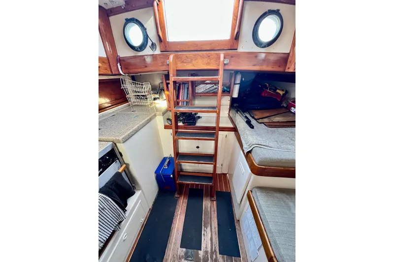 Slide: The Image of Interior of 1975 Cape George 36 sailboat with wooden ladder and cozy seating. - 74