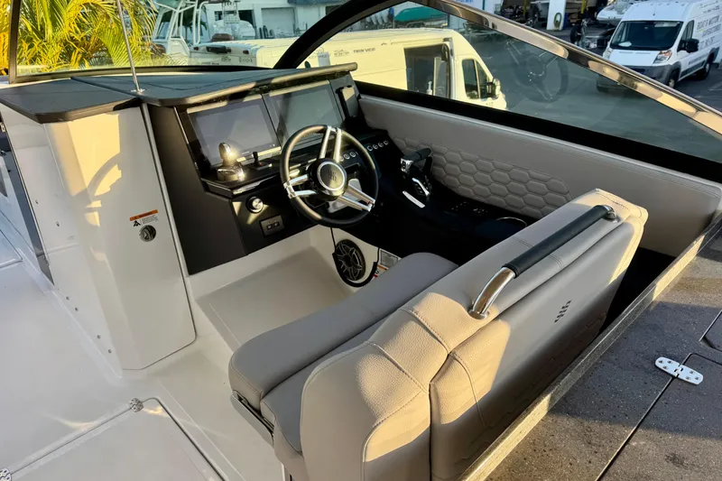 Slide: The Image of 2026 Four Winns H33 OB boat cockpit with modern steering and dashboard controls. - 16