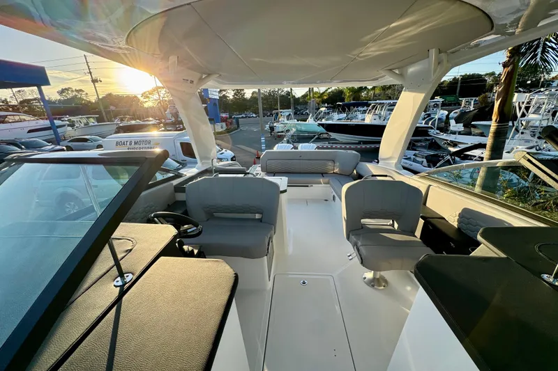 Slide: The Image of 2026 Four Winns H33 OB boat interior with seating, helm, and sunset view. - 25