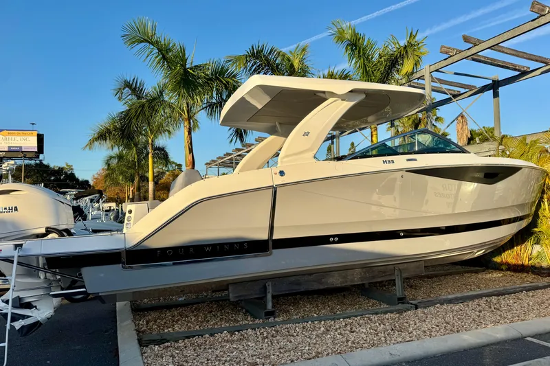 Slide: The Image of 2026 Four Winns H33 OB boat displayed outdoors with palm trees in the background. - 3