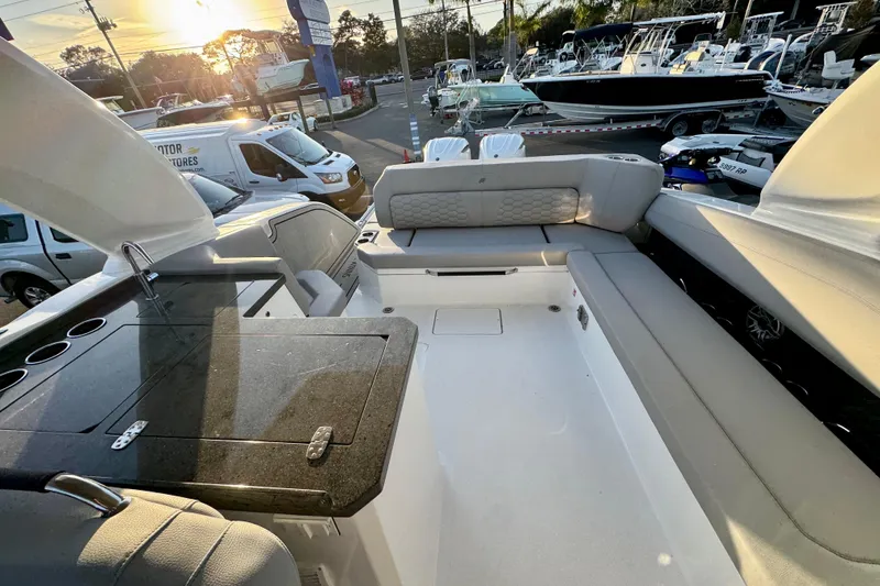 Slide: The Image of 2026 Four Winns H33 OB boat interior with seating and countertop at sunset. - 30