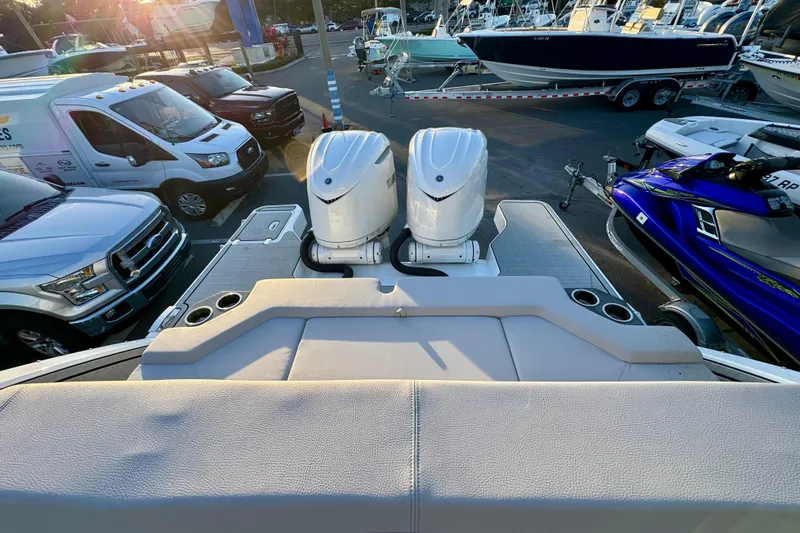 Slide: The Image of 2026 Four Winns H33 OB boat with dual outboard engines in a marina setting. - 33