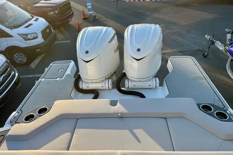 Slide: The Image of 2026 Four Winns H33 OB boat with dual outboard engines in a parking lot. - 34
