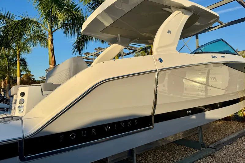 Slide: The Image of 2026 Four Winns H33 OB boat displayed outdoors with palm trees in the background. - 4