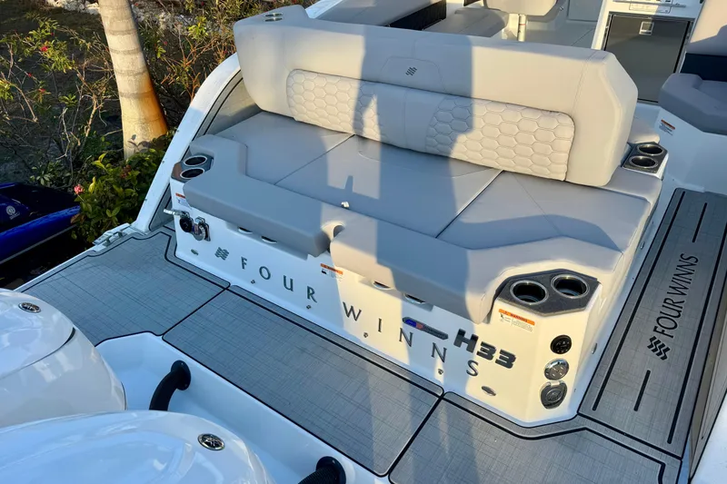 Slide: The Image of 2026 Four Winns H33 OB boat with cushioned seating and cup holders on deck. - 8