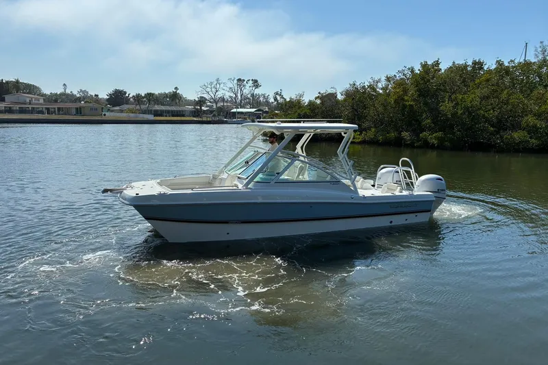 Slide: The Image of 2026 World Cat 230 DC boat cruising on a calm river. - 2