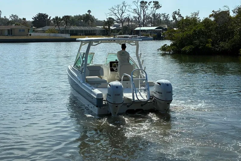 Slide: The Image of 2026 World Cat 230 DC boat cruising on a calm waterway. - 3