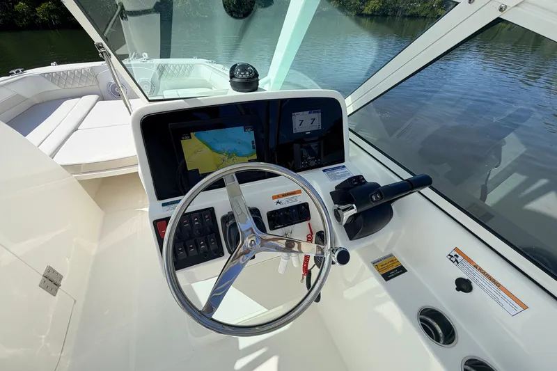 Slide: The Image of Helm of 2026 World Cat 230 DC boat with steering wheel and navigation display. - 5