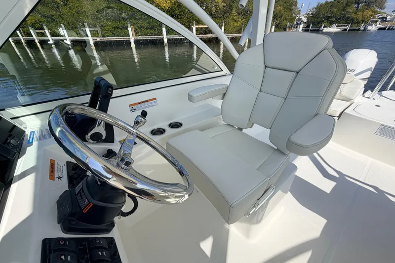 Slide: The Image of Helm of 2026 World Cat 230 DC boat with sleek steering wheel and comfortable seating. - 6