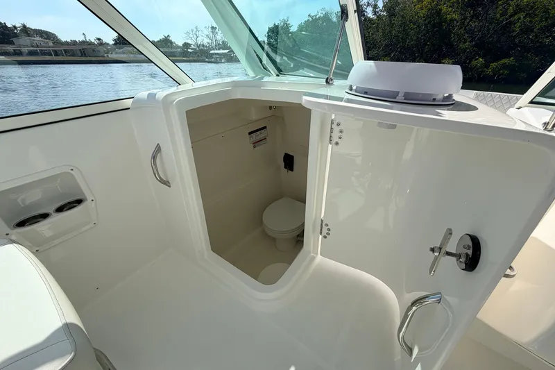 Slide: The Image of Interior view of 2026 World Cat 230 DC boat's compact bathroom area. - 9