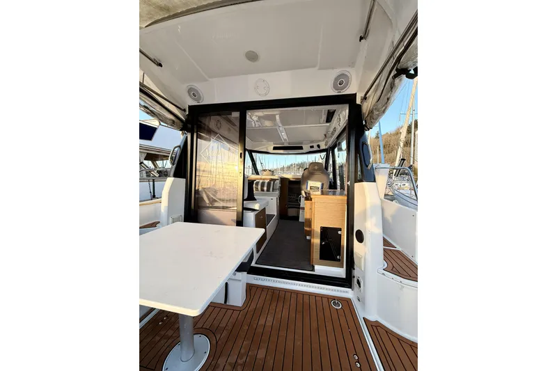 Slide: The Image of 2022 Jeanneau NC Weekender 895 interior view with wooden deck and seating area. - 17