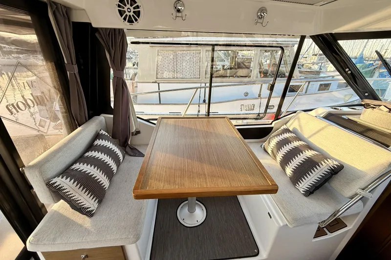 Slide: The Image of Interior of 2022 Jeanneau NC Weekender 895 with cozy seating and wooden table. - 23