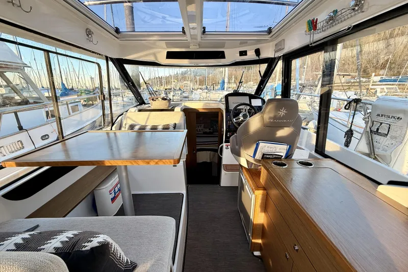 Slide: The Image of Interior of 2022 Jeanneau NC Weekender 895, featuring helm, seating, and dining area. - 24