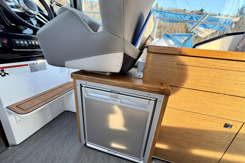 Slide: The Image of Interior of 2022 Jeanneau NC Weekender 895 with helm seat and compact fridge. - 27