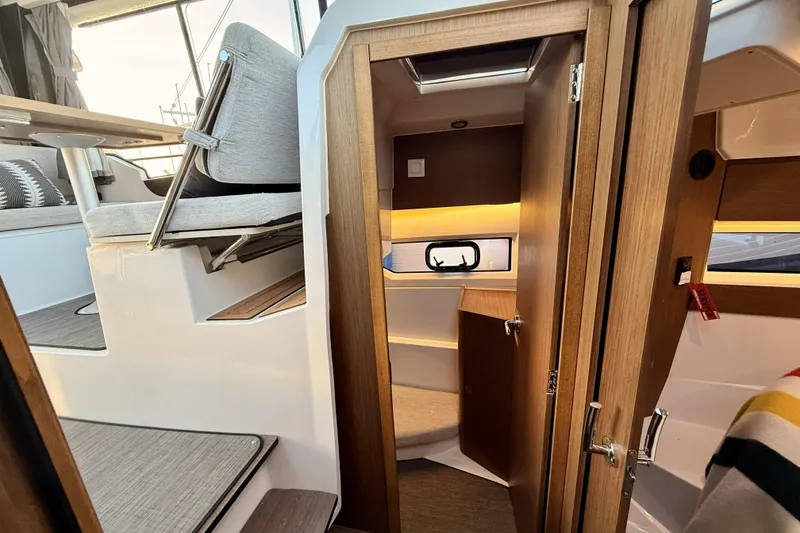 Slide: The Image of Interior of 2022 Jeanneau NC Weekender 895, featuring cozy seating and wooden finishes. - 30
