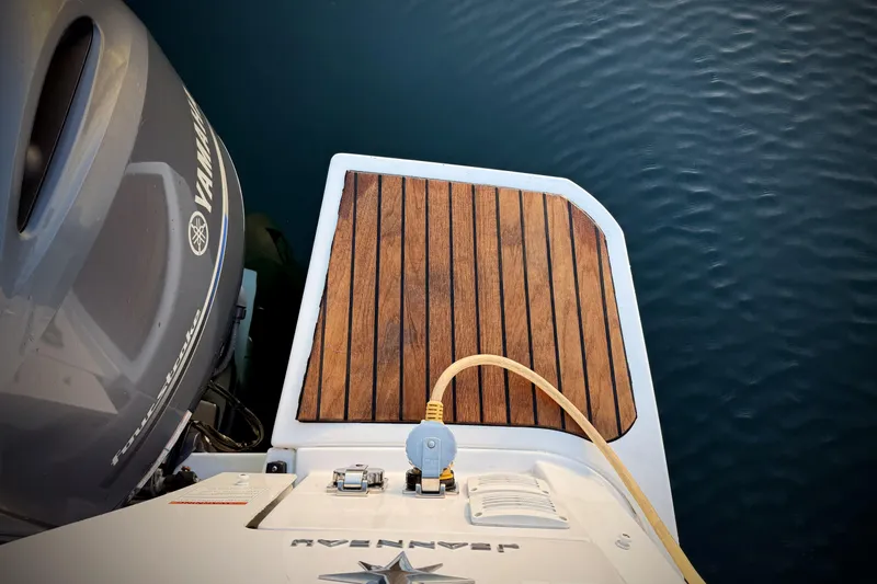 Slide: The Image of 2022 Jeanneau NC Weekender 895 with Yamaha engine, wooden deck, and water backdrop. - 47