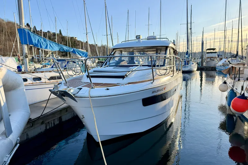 Slide: The Image of 2022 Jeanneau NC Weekender 895 docked in a marina, surrounded by sailboats. - 7
