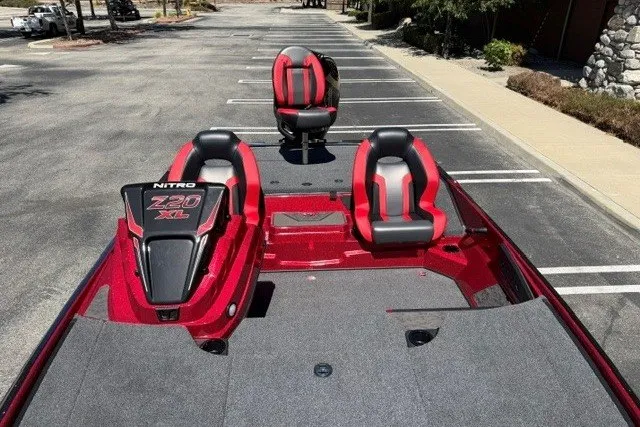 Slide: The Image of 2026 Nitro Z20 XL Pro boat with red and black seating in a parking lot. - 5