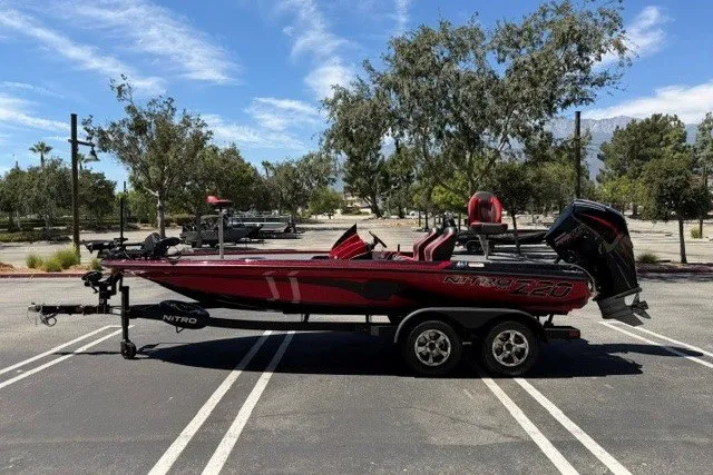 Slide: The Image of 2026 Nitro Z20 XL Pro boat in parking lot, red and black design, clear sky background. - 1