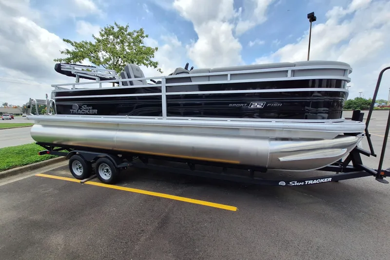 Slide: The Image of 2026 Sun Tracker SportFish 22 DLX pontoon boat on trailer in parking lot. - 4