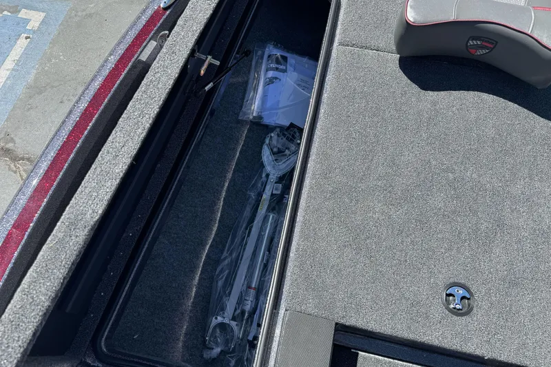 Slide: The Image of Storage compartment of 2026 Triton 18 TrX boat with equipment and manuals. - 11