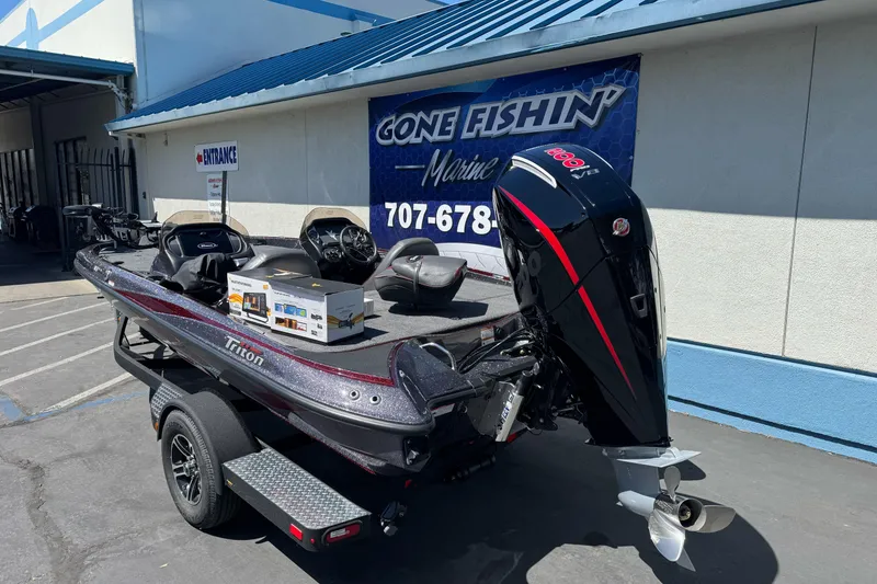Slide: The Image of 2026 Triton 18 TrX boat with powerful outboard motor at dealership. - 6