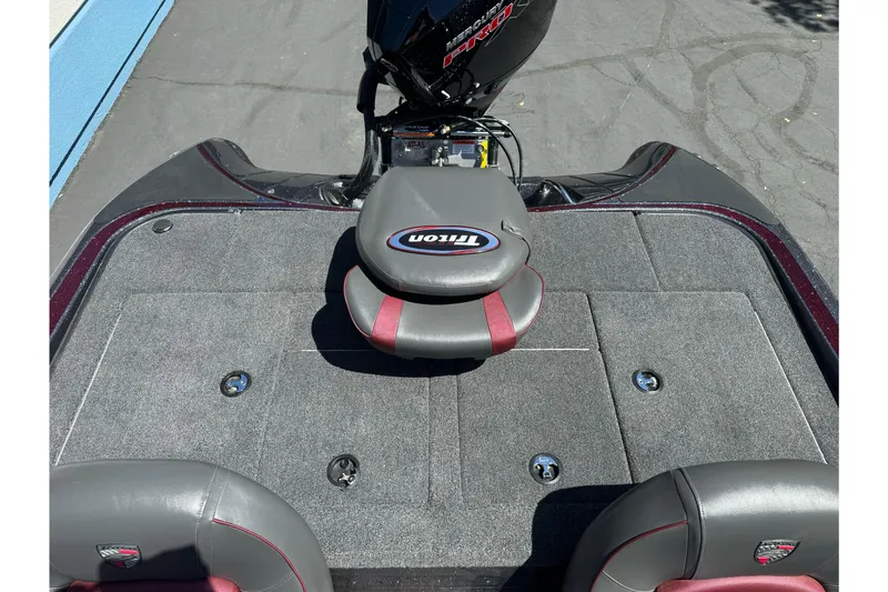 Slide: The Image of 2026 Triton 18 TrX boat interior with gray and red seating, showcasing storage compartments. - 14