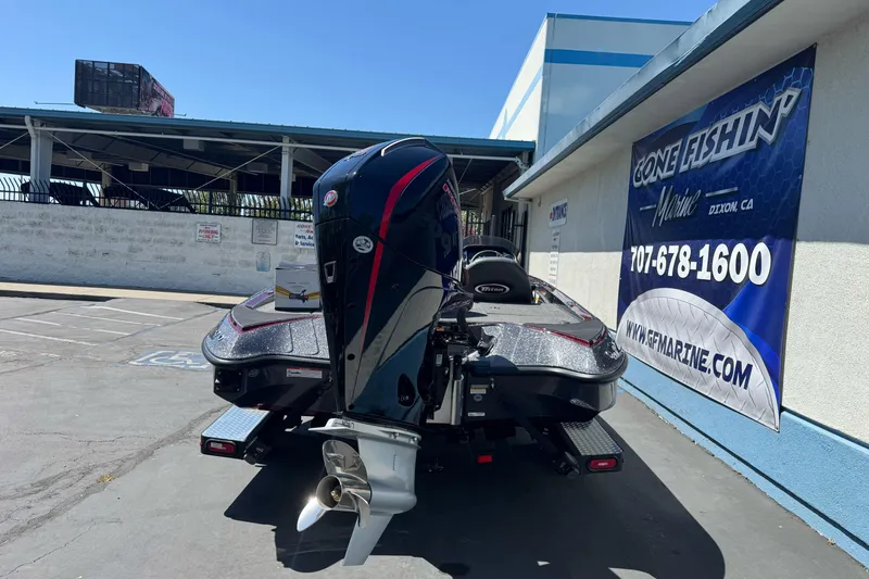 Slide: The Image of 2026 Triton 18 TrX boat with powerful outboard motor, parked at a marine dealership. - 5