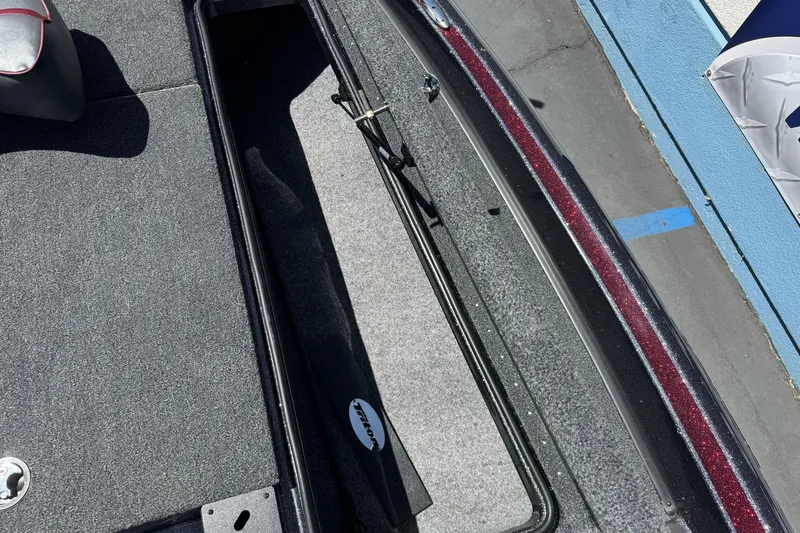 Slide: The Image of Interior view of a 2026 Triton 18 TrX boat storage compartment. - 12