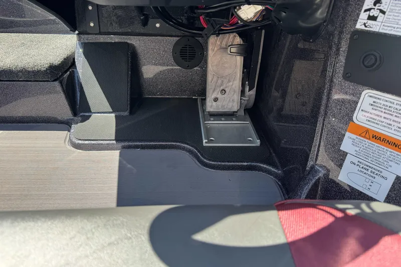 Slide: The Image of Interior view of a 2026 Triton 18 TrX boat, showcasing foot pedal and warning labels. - 22