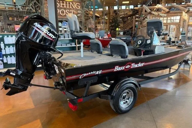 Slide: The Image of 2026 Tracker Bass Tracker Classic XL boat with Mercury engine on display indoors. - 2