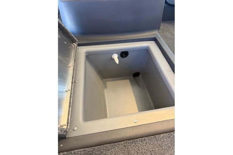Slide: The Image of 2026 Tracker Bass Tracker Classic XL livewell with open lid and drain plug. - 8