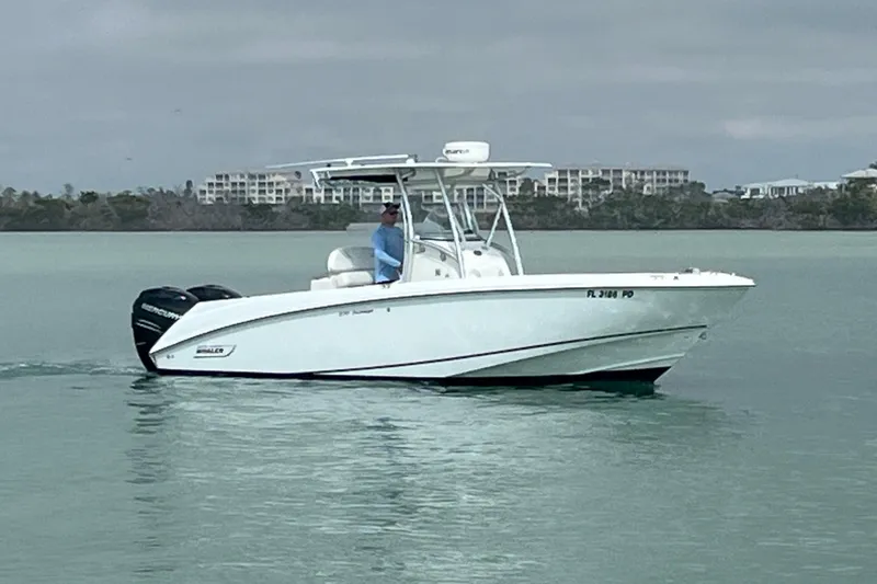 The Image of 2007 Boston Whaler 270 Outrage boat cruising on calm waters near shoreline. - 0