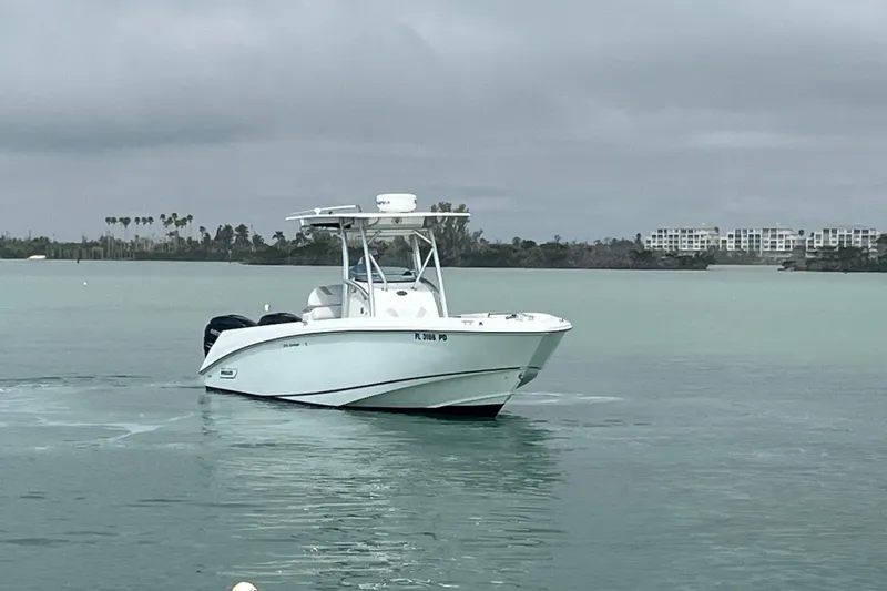 Slide: The Image of 2007 Boston Whaler 270 Outrage boat on calm water with cloudy sky backdrop. - 1