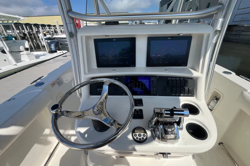 Slide: The Image of 2007 Boston Whaler 270 Outrage helm with dual screens and steering wheel at marina. - 10