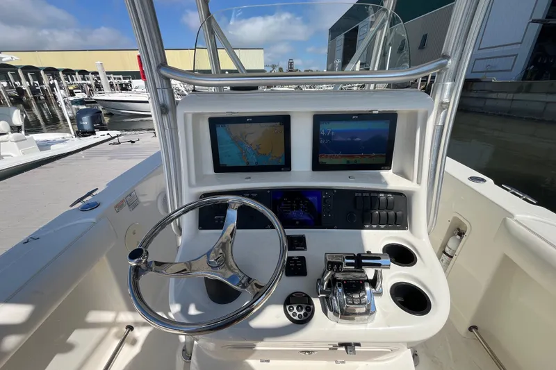 Slide: The Image of 2007 Boston Whaler 270 Outrage helm with dual displays and steering wheel at marina. - 11
