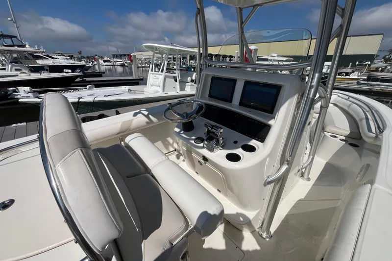 Slide: The Image of 2007 Boston Whaler 270 Outrage boat interior with helm, steering wheel, and navigation screens. - 12