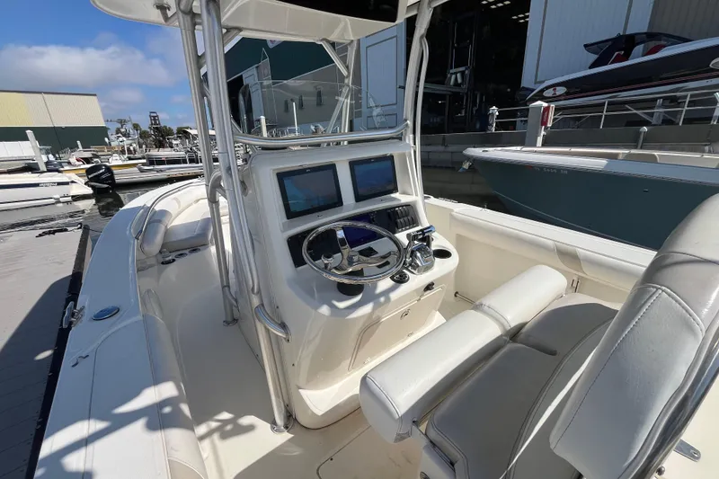 Slide: The Image of 2007 Boston Whaler 270 Outrage boat interior with helm and seating at marina. - 13