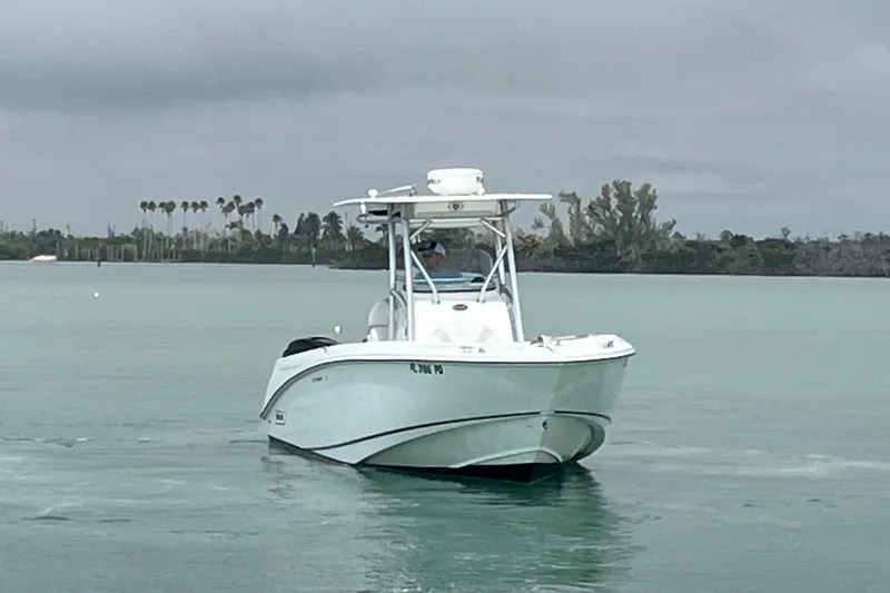 Slide: The Image of 2007 Boston Whaler 270 Outrage boat on calm water with cloudy sky backdrop. - 2