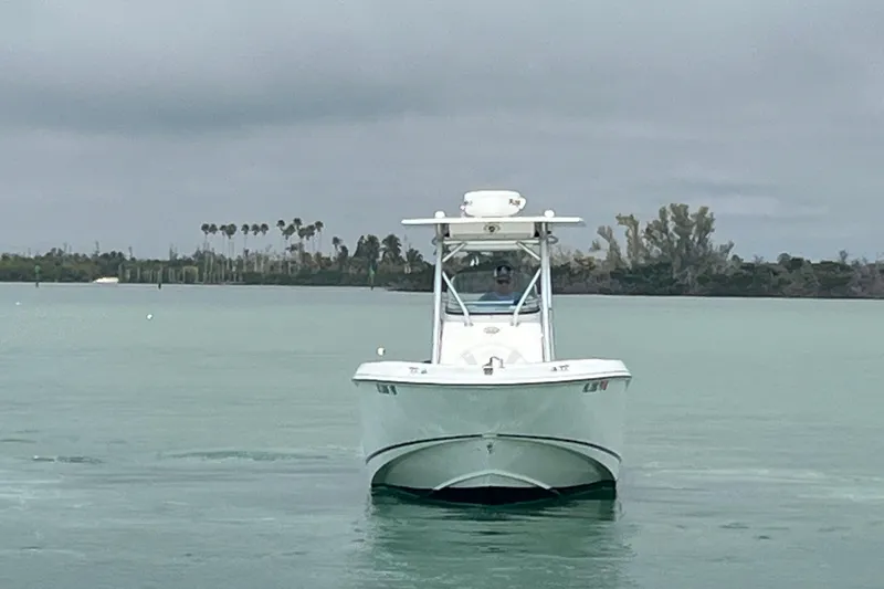 Slide: The Image of 2007 Boston Whaler 270 Outrage boat on calm water, overcast sky, distant shoreline. - 3