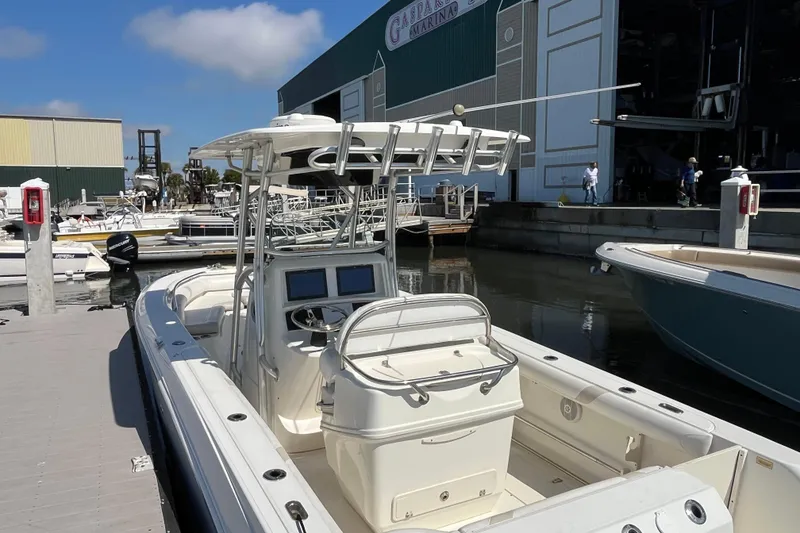 Slide: The Image of 2007 Boston Whaler 270 Outrage docked at marina, showcasing helm and seating area. - 31