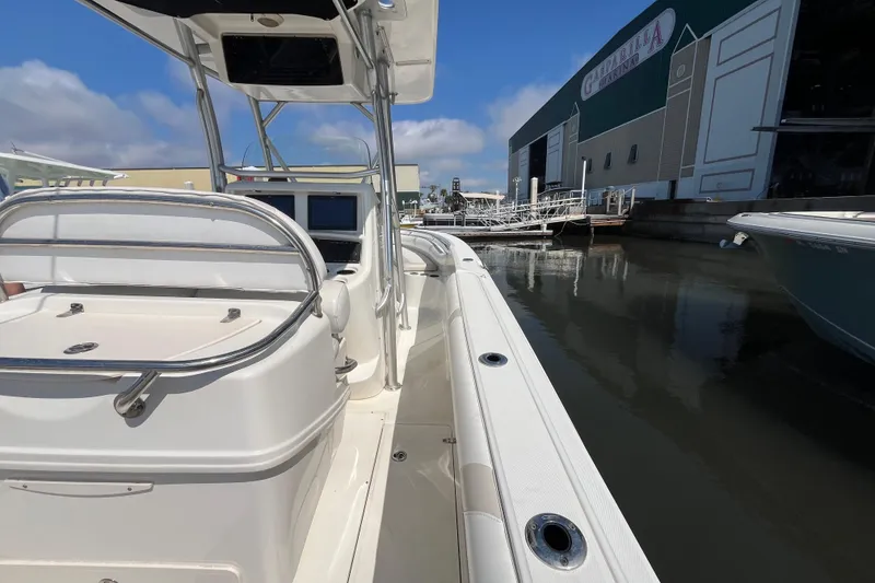 Slide: The Image of 2007 Boston Whaler 270 Outrage docked near marina, clear sky background. - 8