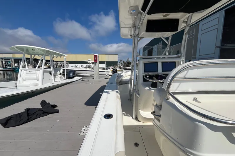 Slide: The Image of 2007 Boston Whaler 270 Outrage docked at marina under clear blue sky. - 9