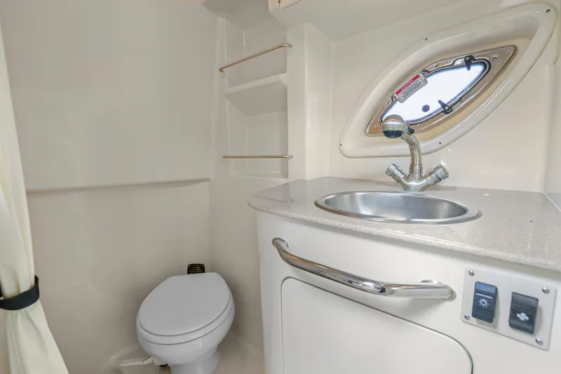 Slide: The Image of 2007 Sea Ray 310 Sundancer bathroom with sink, toilet, and porthole window. - 12