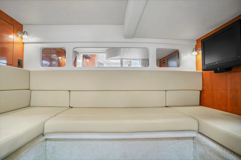 Slide: The Image of Interior of 2007 Sea Ray 310 Sundancer with beige seating and wall-mounted TV. - 14