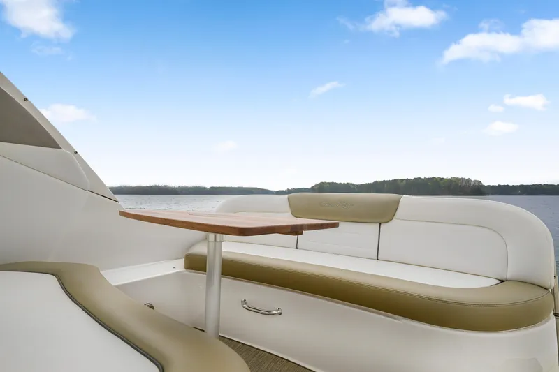Slide: The Image of 2007 Sea Ray 310 Sundancer boat interior with seating and table, under a clear blue sky. - 15