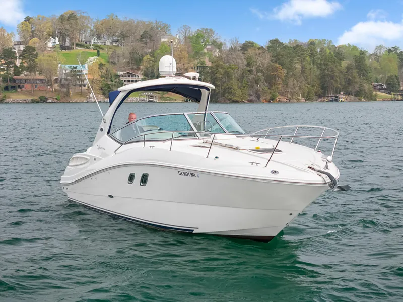 Slide: The Image of 2007 Sea Ray 310 Sundancer boat on a scenic lake with wooded shoreline. - 3