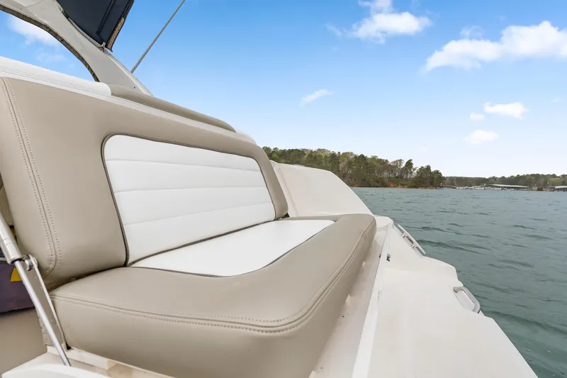 Slide: The Image of 2007 Sea Ray 310 Sundancer boat with beige and white seating on a calm lake. - 31