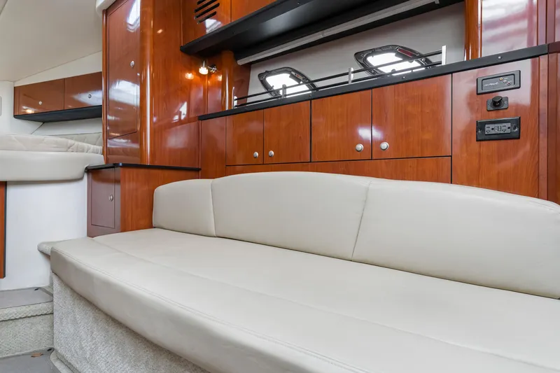 Slide: The Image of Interior of 2007 Sea Ray 310 Sundancer with beige seating and wooden cabinetry. - 6